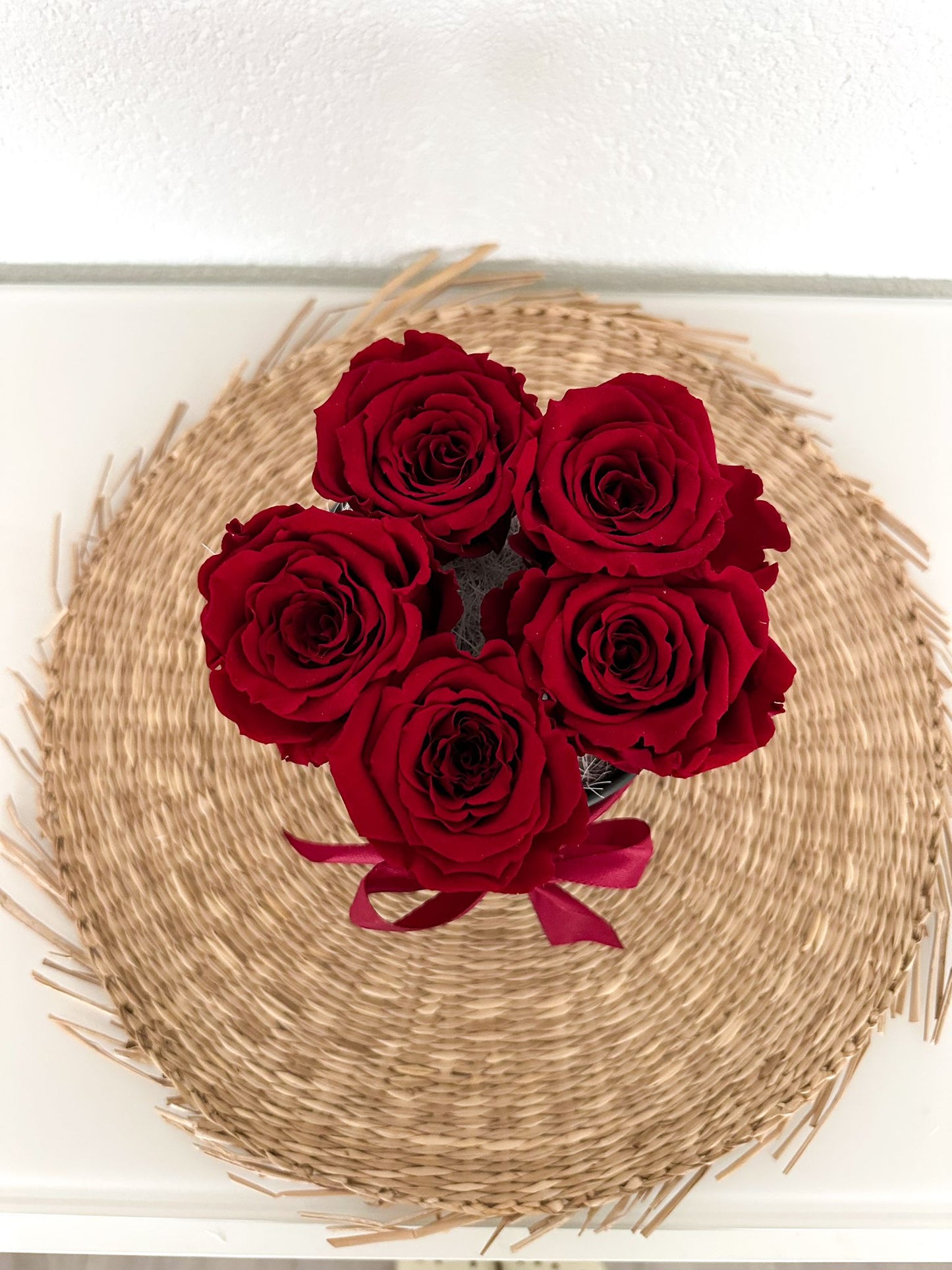 Nahaufnahme der Rosenbox mit fünf stabilisierten Rosen in tiefem Bordeauxrot und hochwertiger Dekoration.